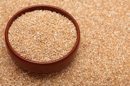 Bulgur wheat in bowl on bulgur wheat background. Close-up.の写真素材