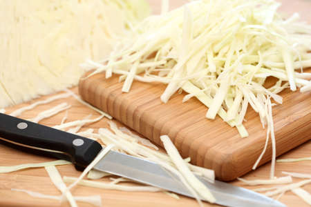Shredded cabbage on the cutting board and knife. SDOF. Close-up.の写真素材