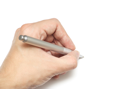 Young man's hand holding a ball-point penの写真素材