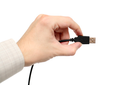 Hand holding USB cable against white background