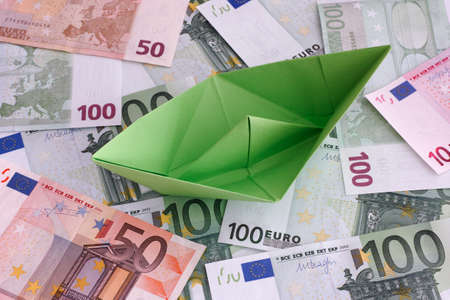 Green paper boat on Euro banknotes.の写真素材