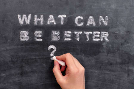 Womans hand writing What Can Be Better question on blackboard.の写真素材