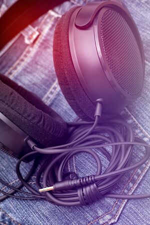 Headphones laying on a jeans. Light effect. Closeup.の写真素材