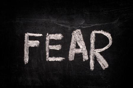 Word Fear on a blackboard writing with chalk. Close up.の写真素材