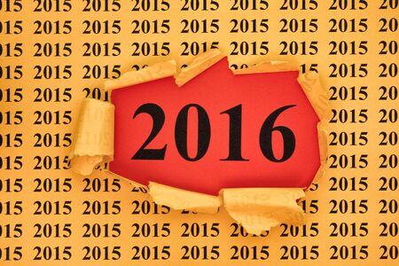 Year 2016 appears through the torn yellow paper with 2015 year background.の写真素材
