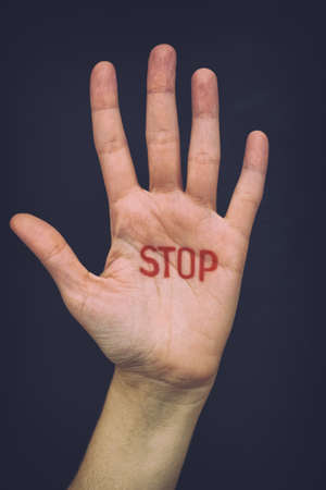 Hand with writting Stop. Close up.