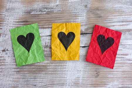 Colorful paper hearts on a wooden background. Close up.