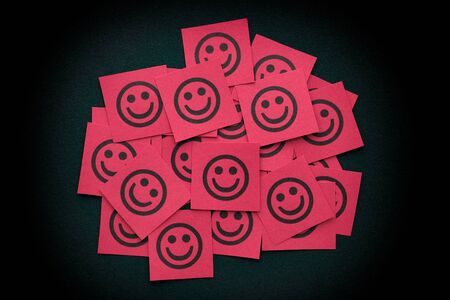 Red paper notes with happy faces. Close up.の写真素材