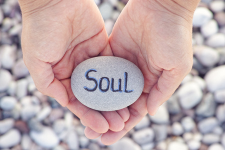 Soul. Woman holding stone with the word Soul in her palms. Close up.の写真素材