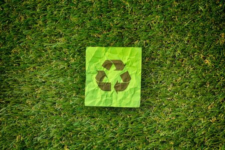 Recycle symbol laying on a green grass. Concept image.の写真素材