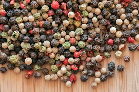 Mixed peppercorn on a wooden table. Closeup.