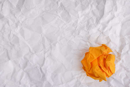 Yellow paper ball on crumpled paper background. Idea Concept.の写真素材