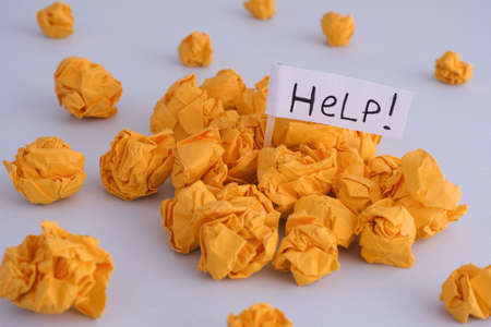 Yellow crumpled paper balls and flag with Help word written on it. Idea Ñoncept.の写真素材
