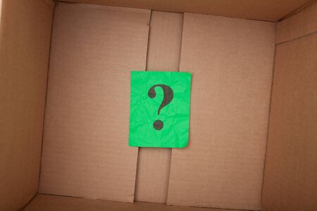 Question mark inside of a cardboard box. Close up.