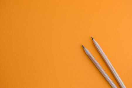 Two pencils on a yellow background. Close up.の写真素材