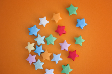 Colorful origami lucky stars on yellow background. Close up.の写真素材