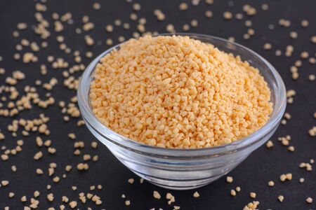  Soy lecithin in a bowl on black background. Close up.