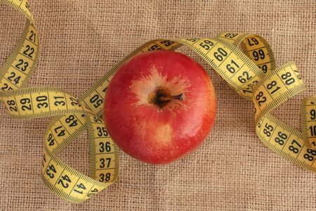 Red Apple and Yellow Measuring Tape. Diet Concept. Close up.