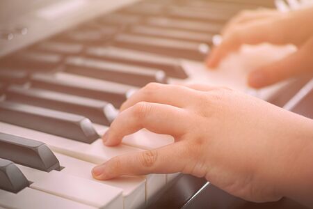Child playing on a digital piano. Close up.の写真素材