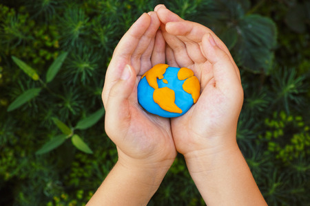 Young boy holding planet Earth in his hands. Concept image.の写真素材