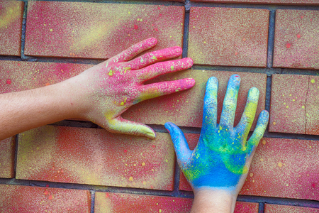 Painted hands on brick wall. Close up.の写真素材