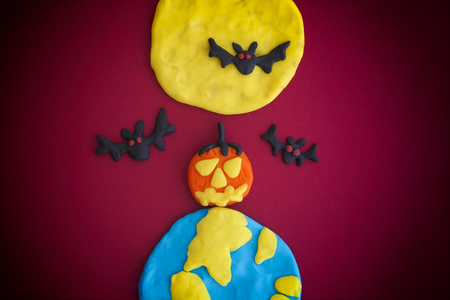 Happy Halloween. The Moon, Earth, pumpkin and bats are made out of modeling clay.の写真素材