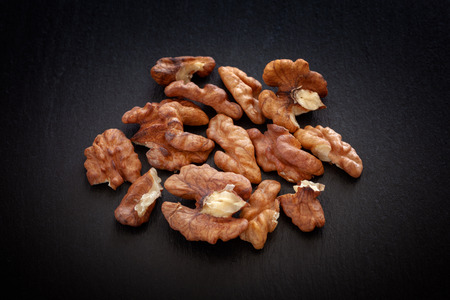 Walnuts on a black slate background. Close up.