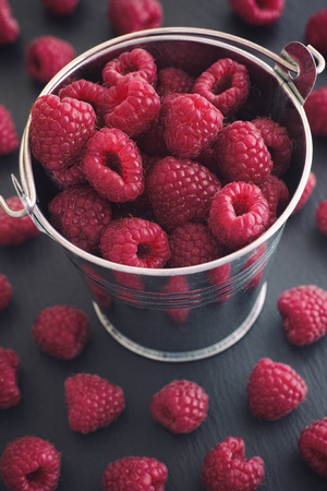 Ripe raspberries in a small bucket. Close up.の写真素材