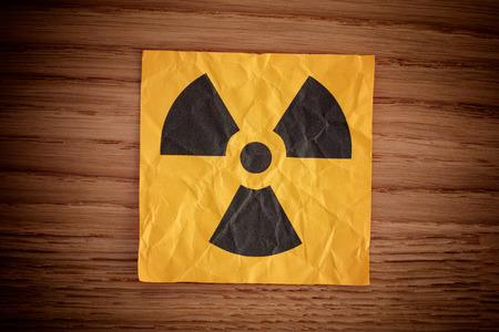 Radiation warning sign on a wooden board. Close up.