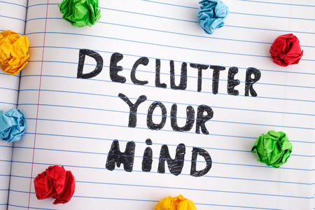Declutter Your Mind. Phrase Declutter Your Mind on notebook sheet with colorful crumpled paper balls...