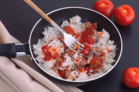 Rice with turkey minced meat and organic tomato sauce in frying pan. Close up.の写真素材