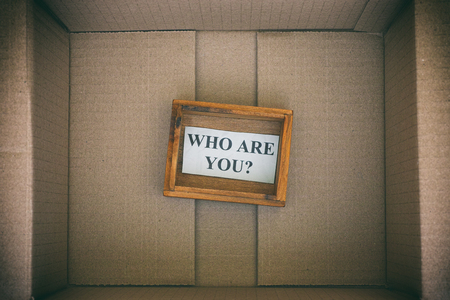 Wooden box with question Who are you inside cardboard box. Concept image. Close up.の写真素材