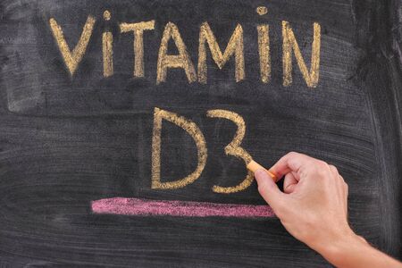Hand writing Vitamin D3 on chalkboard. Close up.の写真素材