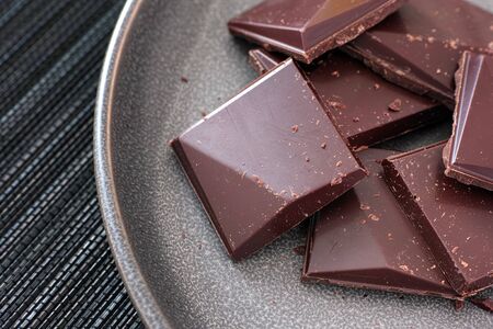 Pieces of dark chocolate on a plate. Close up.の写真素材
