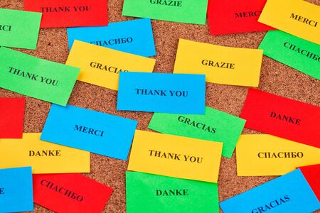 Thank you in many languages on colorful pieces of paper. Close up.の写真素材