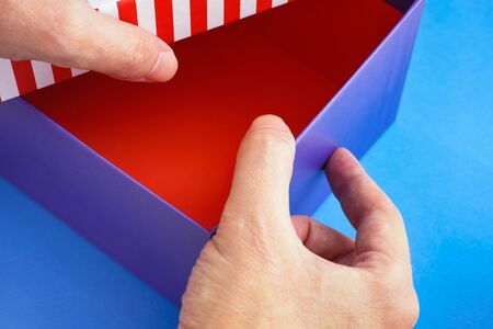 Hands opening a cardboard box. Close up.