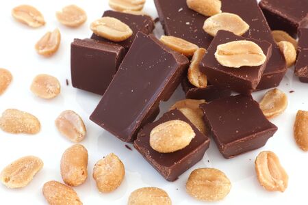 Broken dark chocolate and salted peanuts. Dairy free and gluten free. Close up.