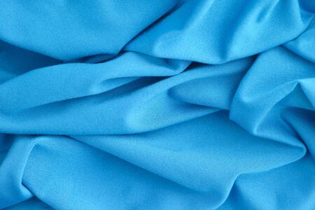 Blue wrinkled fabric texture background. Close up.