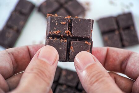 Man holding homemade dark chocolate in his hands. Close up.の写真素材