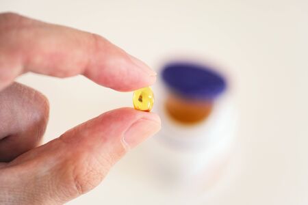 Vitamin D capsule in a hand. Close up.