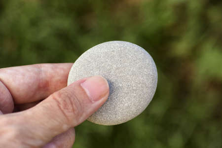 Man holding a stone in his hand. Close up.の写真素材