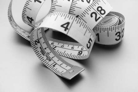 A curled tape measure. Black and white image. Close up.