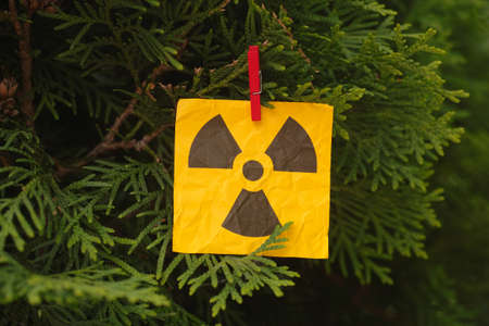 A radiation warning sign hanging on a tree. Close up.の写真素材