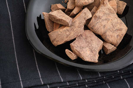 Cacao paste in a black plate. Theobroma cacao. Low key.の写真素材