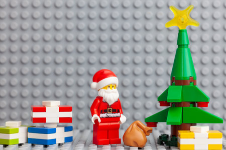 Tambov, Russian Federation - November 4, 2020 Lego minifigure Santa Claus standing near a Christmas tree with gifts under it.のeditorial素材