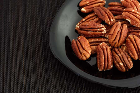 Pecan nuts in a plate. Low key. Close up.