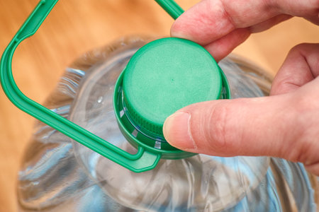 Person opening a water bottle. Close up.