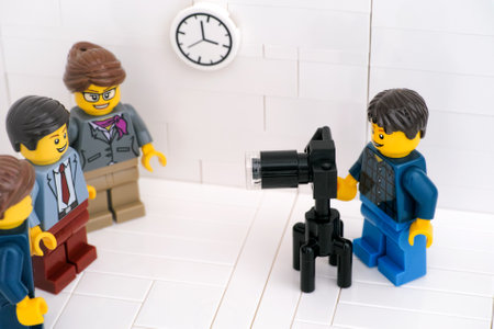 Tambov, Russian Federation - March 24, 2021 A Lego photographer taking photographs of Lego businesspeople in their office.のeditorial素材
