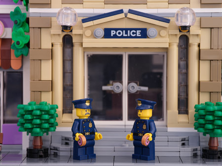 Tambov, Russian Federation - July 02, 2021 Two Lego policeman minifigures standing in front of their police station and eating donuts.のeditorial素材