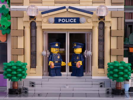 Tambov, Russian Federation - July 02, 2021 Two Lego policeman minifigures standing in front of their police station and eating donuts.のeditorial素材